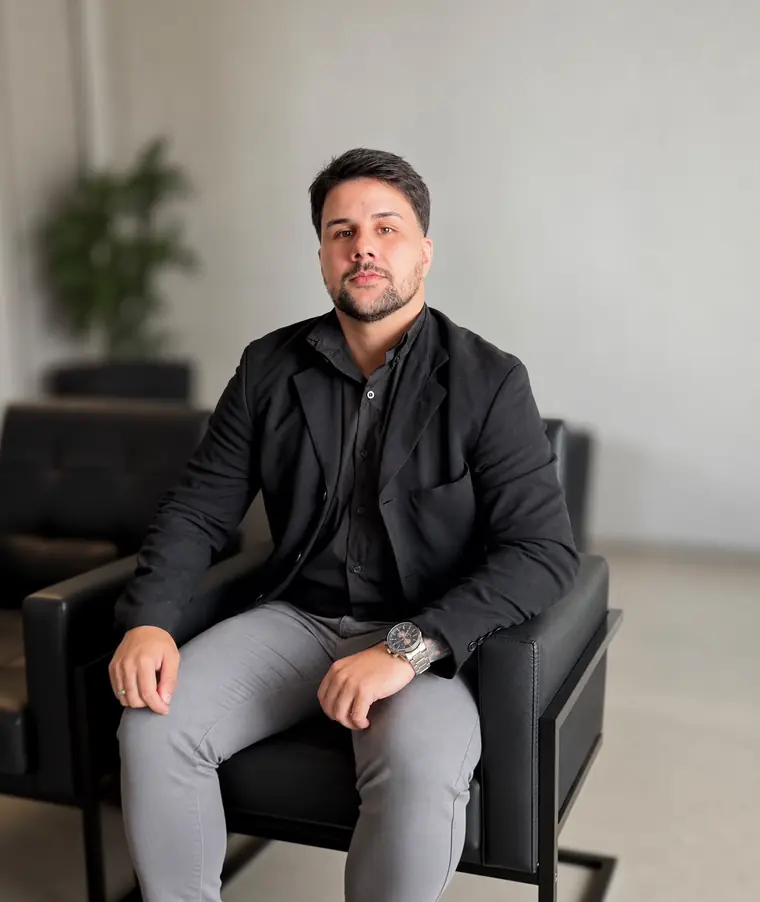 Ruan Gomes, fundador da Vortyx, sentado em uma poltrona preta, vestindo blazer e camisa pretos